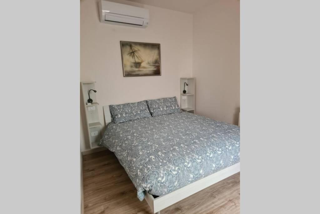 sypialnia z łóżkiem w białym pokoju w obiekcie Tranquillo Appartamento in piazza w mieście Grosseto