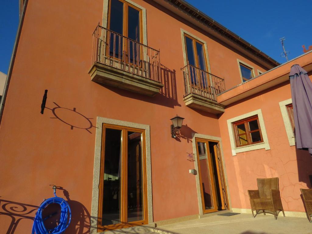 ein orangefarbenes Gebäude mit 2 Balkonen und einer Terrasse in der Unterkunft Casa do Sol in Arouca