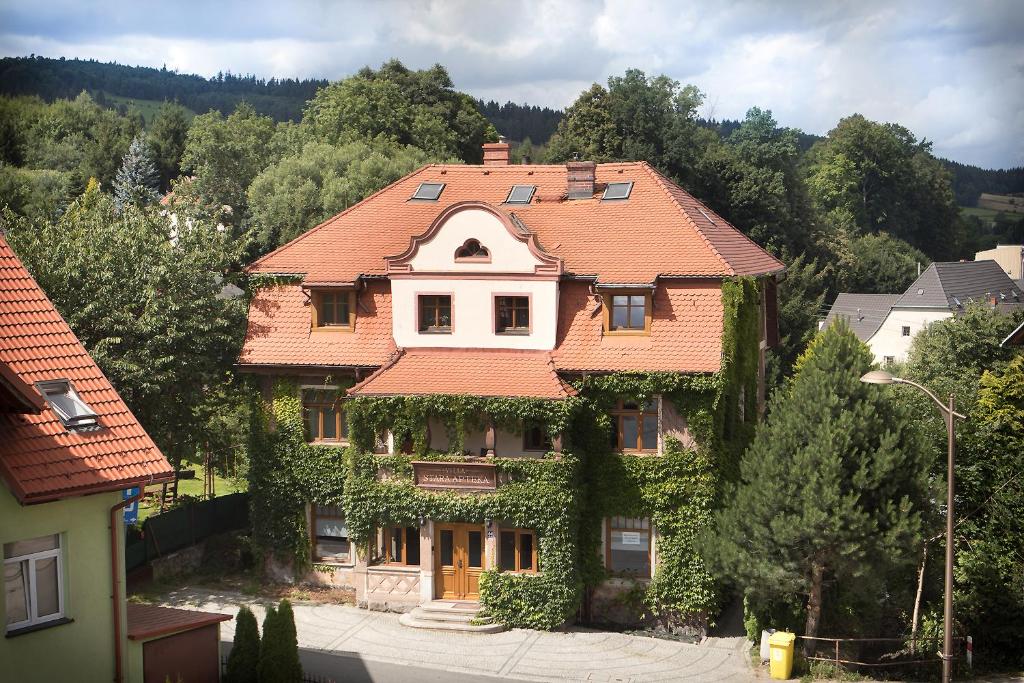 dom z pomarańczowym dachem z bluszczem w obiekcie Apartamenty Stara Apteka w Stroniu Śląskim