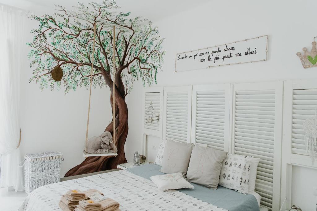 ein Schlafzimmer mit einem Bett mit einem Baum an der Wand in der Unterkunft Casa Romito in Trani