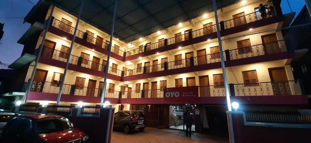 a lit up building with cars parked in front of it at SK Residency in Ooty