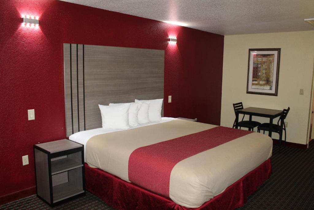 Habitación de hotel con cama grande y escritorio. en Scottish Inns Fort Worth, en Fort Worth