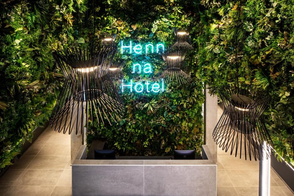 a lobby with a green wall with plants at Henn na Hotel New York in New York