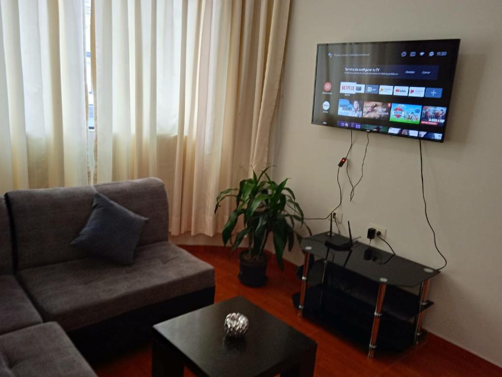 sala de estar con sofá y TV de pantalla plana en 201 Departamento exclusivo en Chorrillos, en Lima