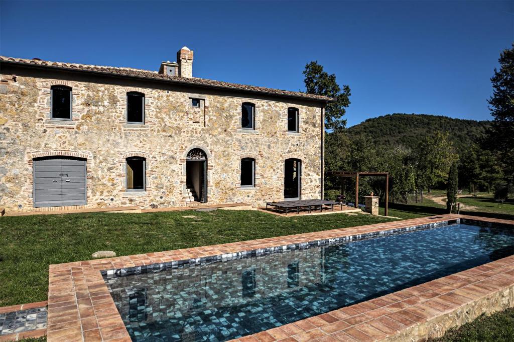 ein Steinhaus mit einem Pool davor in der Unterkunft Tenuta San Galgano in Monticiano