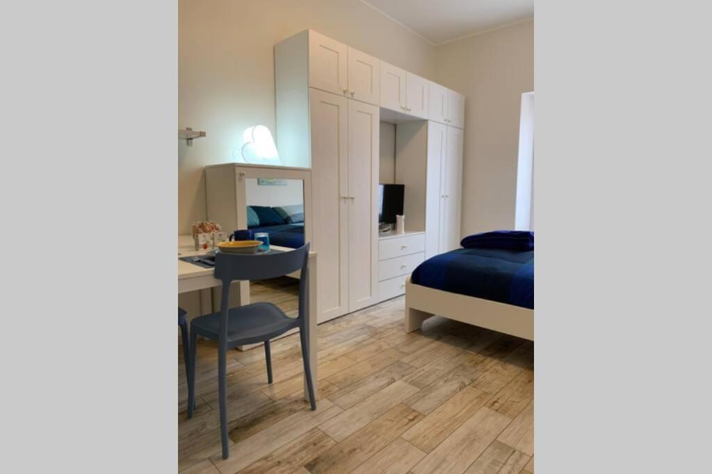 um quarto com uma cama, uma secretária, uma cama e uma cadeira em BGY Airport - La Cascinetta em Grassobbio