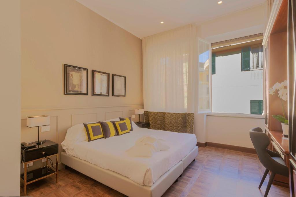 a bedroom with a bed with yellow pillows and a window at Hotel Villa Alberti Portofino Land in Santa Margherita Ligure