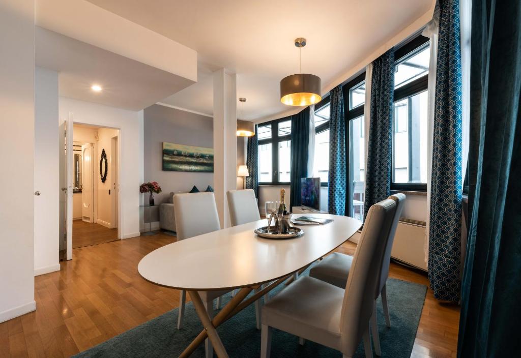 - une salle à manger et un salon avec une table et des chaises dans l'établissement Heart Milan Apartments Duomo Terrace, à Milan