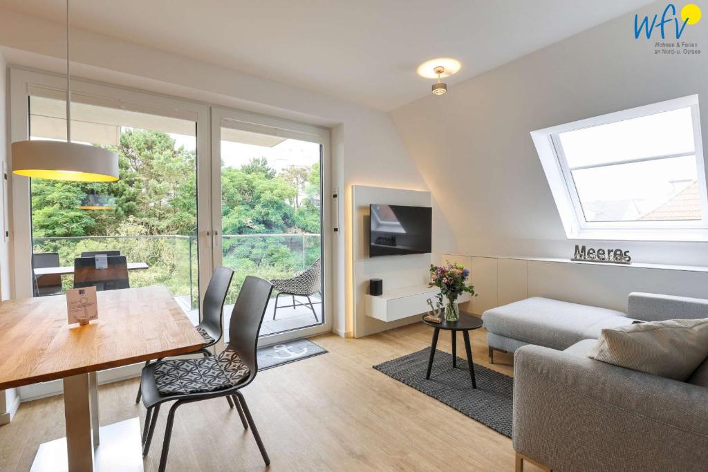a living room with a table and a couch at Haus Talita - Wohnung GOLF in Juist