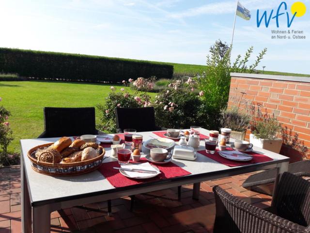 a table with a basket of bread on it at Haus Ebbe und Flut A - Ferienwohnung Deichläufer in Juist