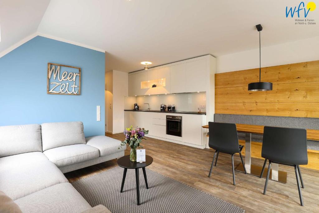 a living room with a couch and a table with chairs at Haus Talita - Wohnung ROMEO in Juist