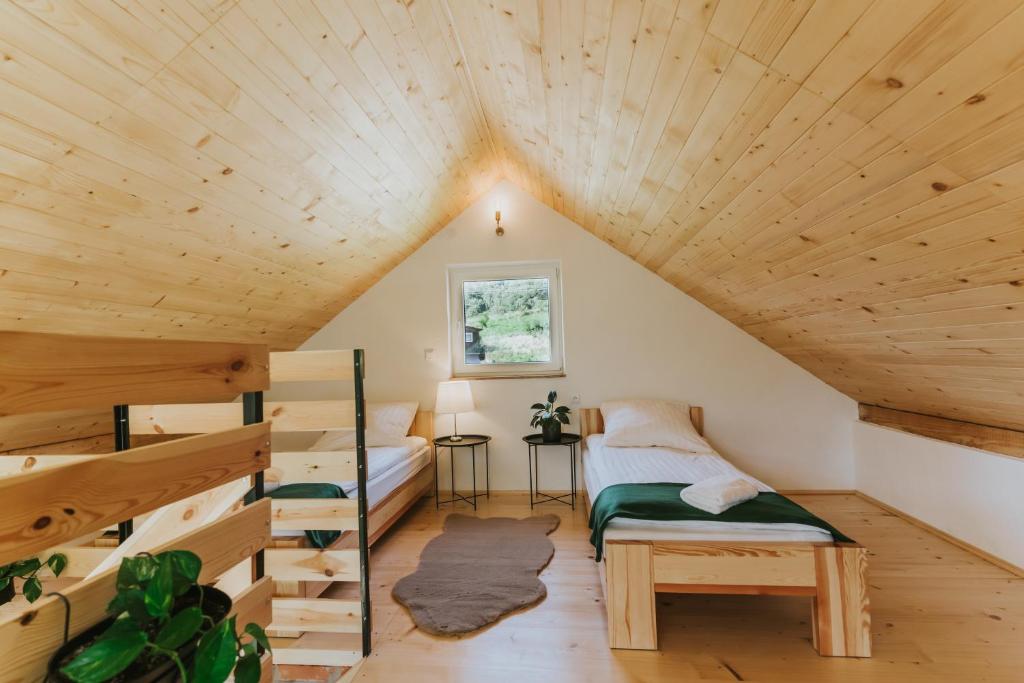 a room with two bunk beds and wooden ceilings at Nowe Domki Jeleni Szlak in Ustrzyki Dolne