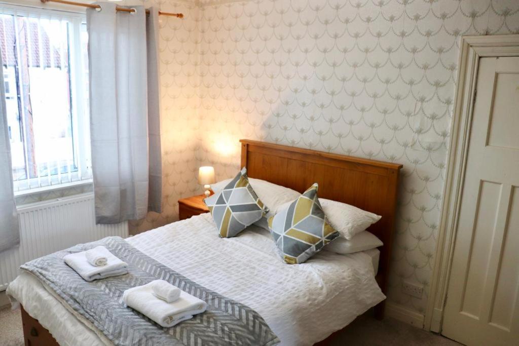 a bedroom with a bed with towels on it at EXQUISITE FOLK VICTORIAN ONE-BED HOUSE: in Leeds
