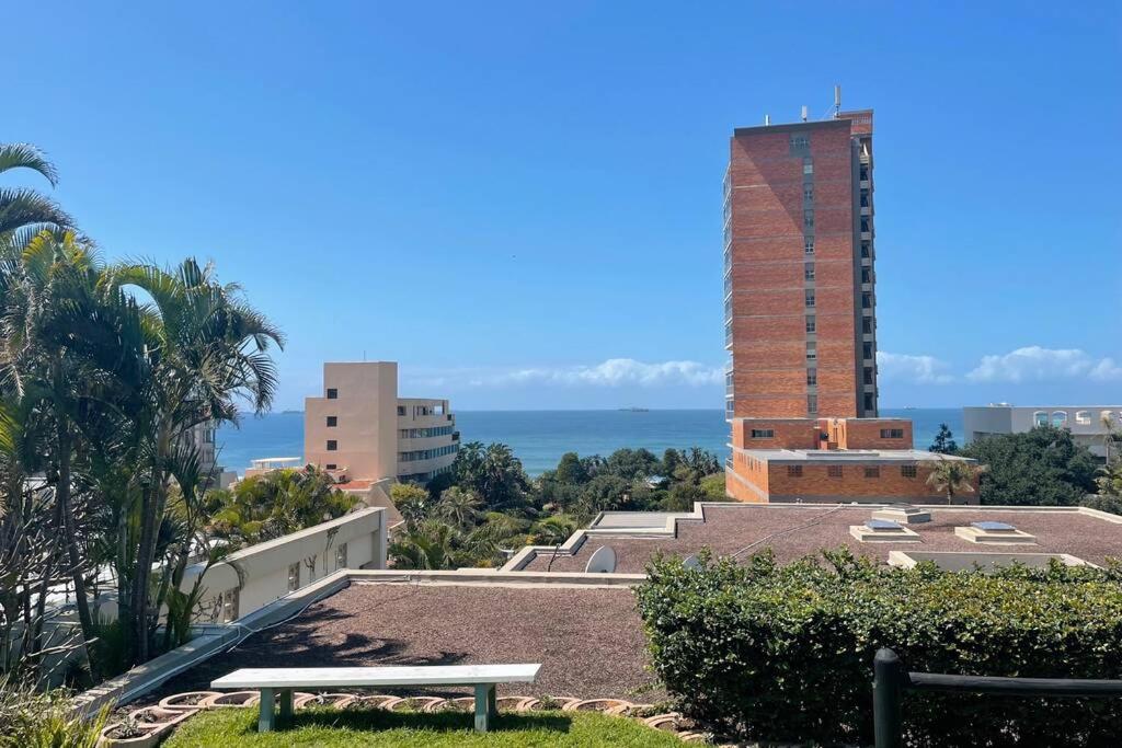 un banco en la parte superior de un edificio con el océano en el fondo en Odenvillea House - Amazing Sea Views, en Durban