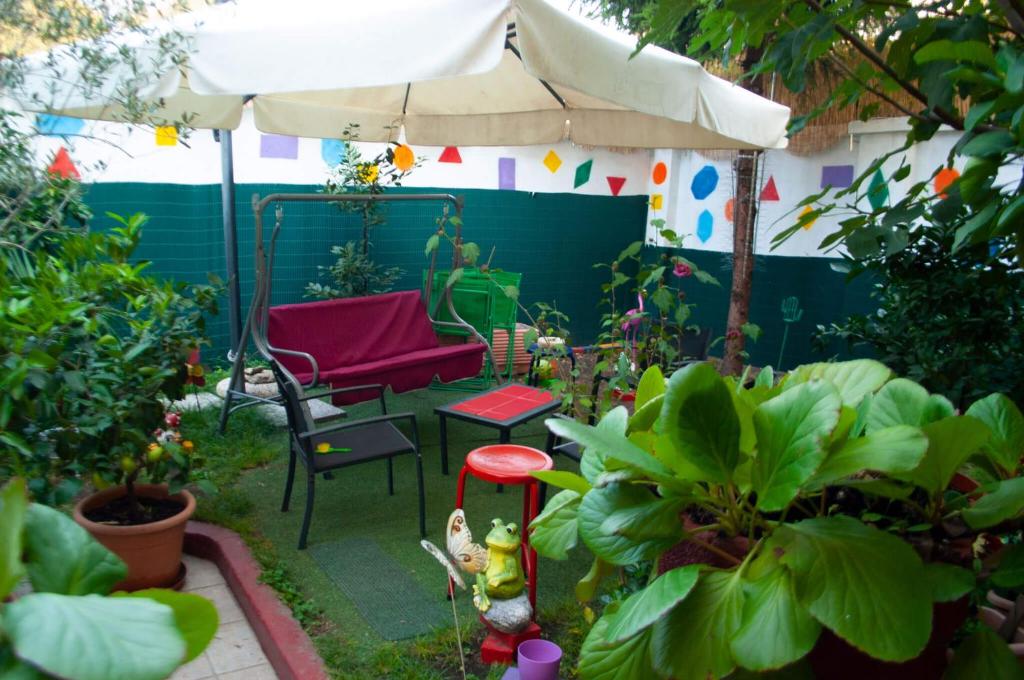 un jardín con una silla, una sombrilla y plantas en B&B Villa Emilia Milano, en Milán