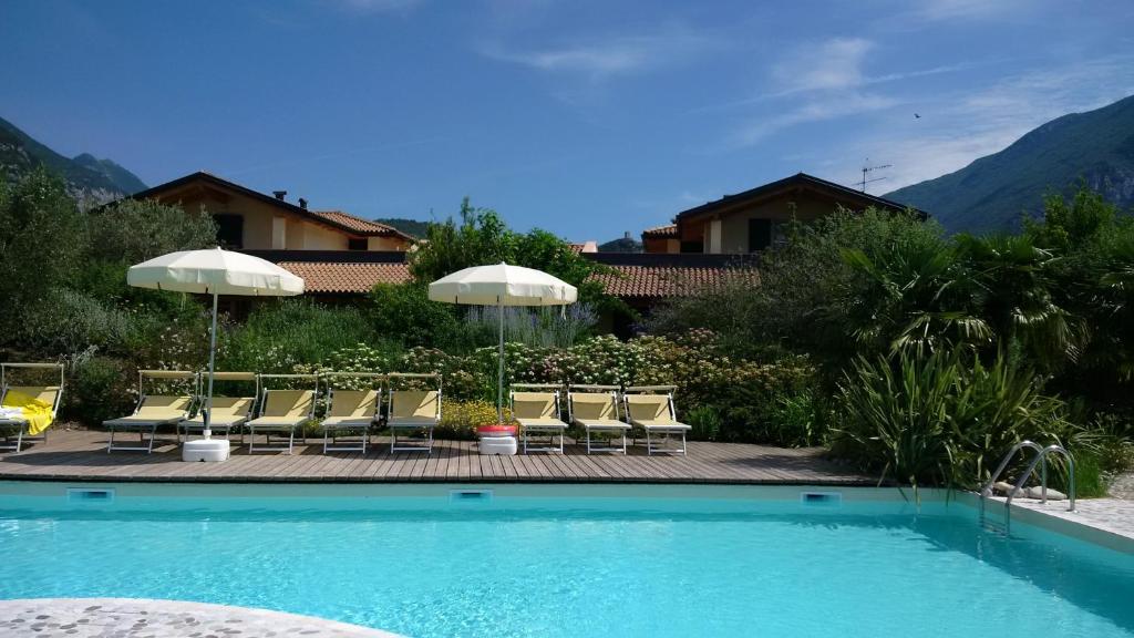una piscina con sillas y sombrillas junto a una casa en Agritur Acquastilla Giovanni Poli, en Arco