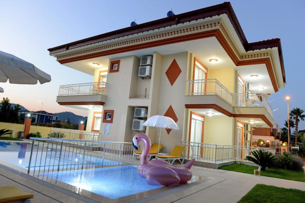 a villa with a swimming pool and a house at can apart hotel in Kemer