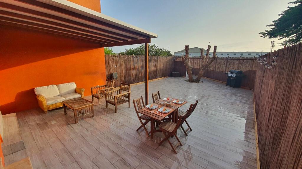 d'une terrasse avec une table, des chaises et un canapé. dans l'établissement Romántico apartamento, piscina y BBQ en Playa La Tejita, à El Médano
