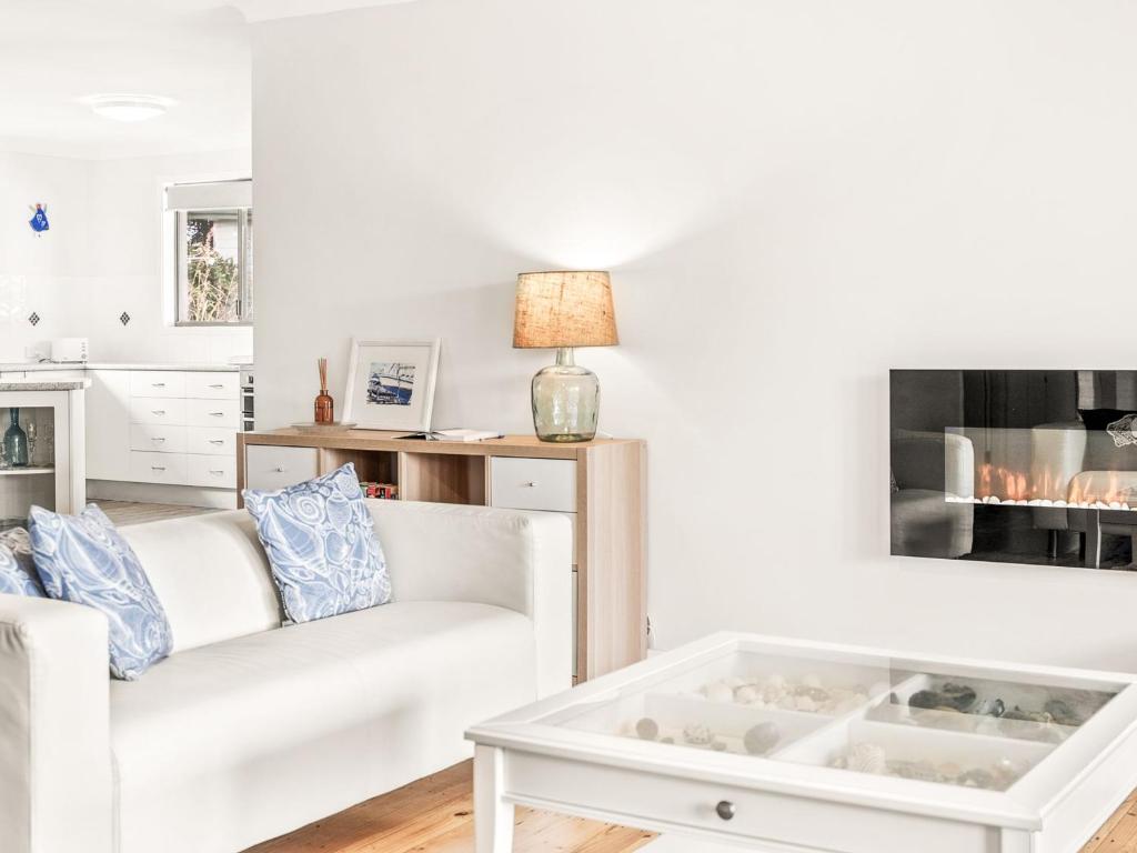 een woonkamer met een witte bank en een salontafel bij The Grey Havens in Evans Head