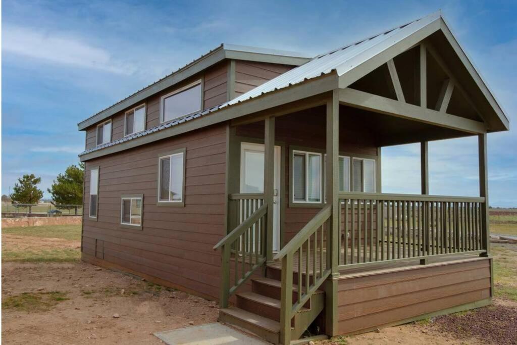 ein kleines Haus mit einer Veranda und einer Terrasse in der Unterkunft 079 Tiny Home nr Grand Canyon South Rim Sleeps 8 in Valle