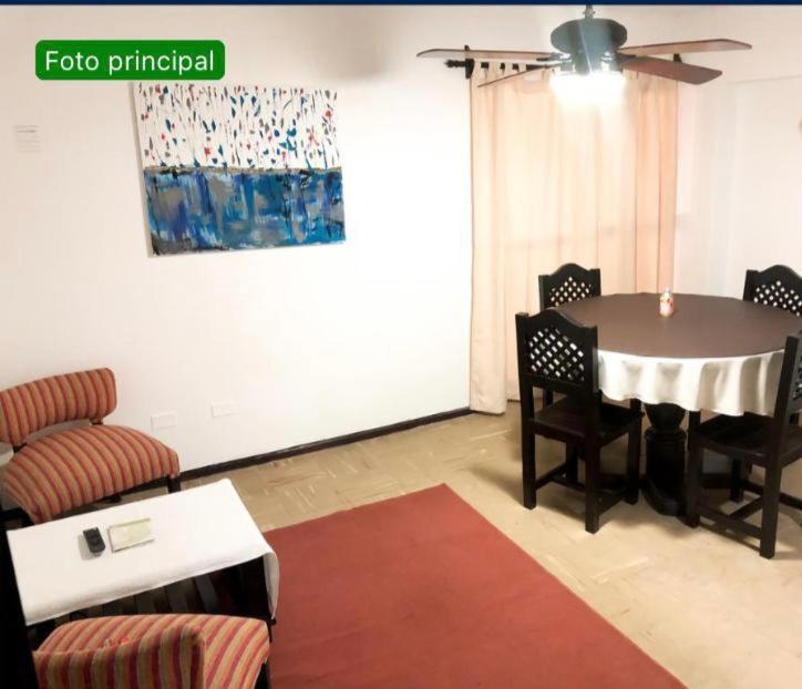 een woonkamer met een tafel en stoelen en een bank bij Depto Temporario Entre Rios 729 in Salta
