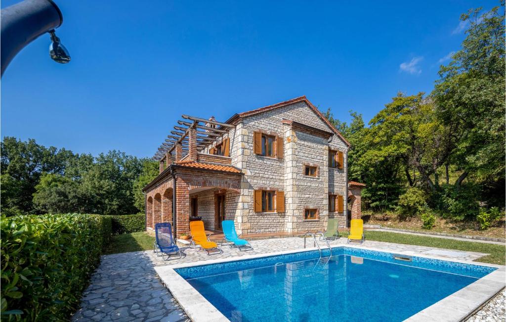 an old house with a swimming pool in front of it at Lovely Home In Dolinci With Outdoor Swimming Pool in Grižane