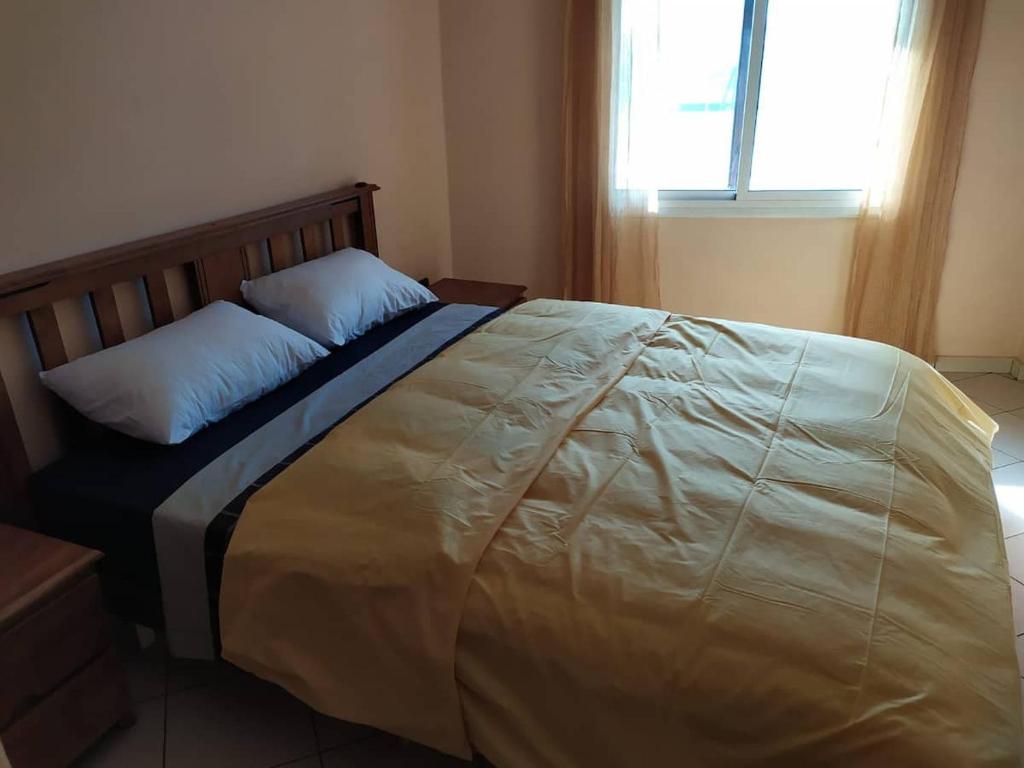 duże łóżko w sypialni z oknem w obiekcie Bright whole apartment 500 meters from the center Air conditioner available in each room w Marakeszu