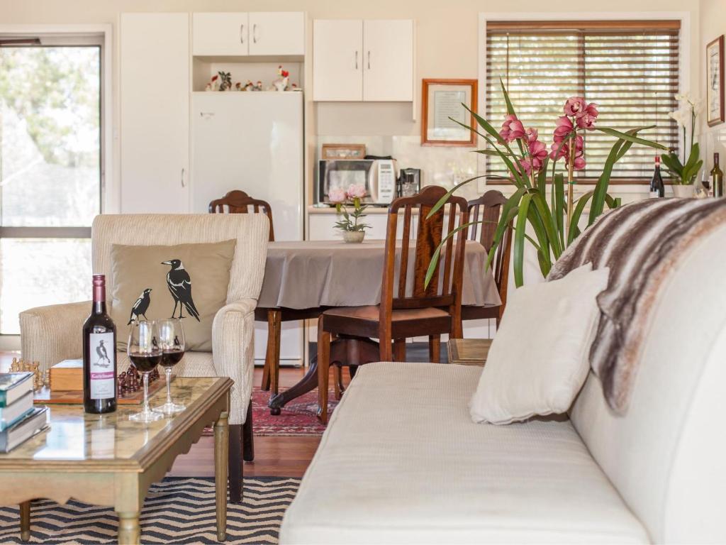 een woonkamer met een bank en een tafel met wijnglazen bij Gartelmann Studio at Gartelmanns Wines in Lovedale