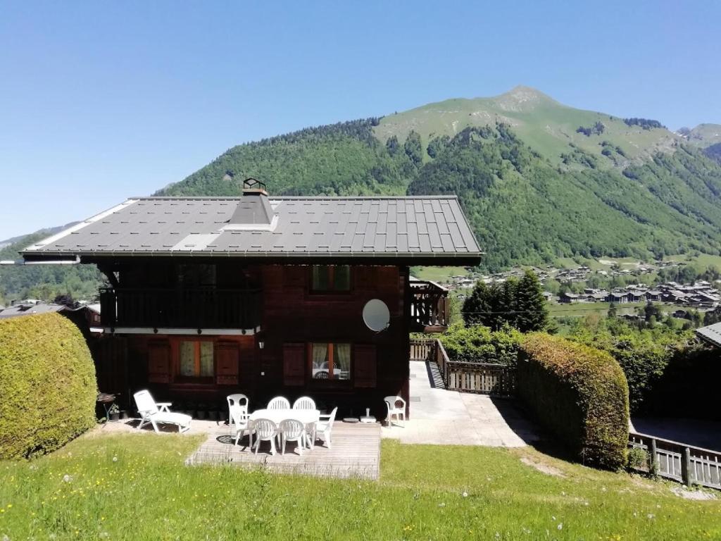 une maison avec des tables et des chaises devant elle dans l'établissement Chalet 8 pers. avec terrasse 69571, à Morzine