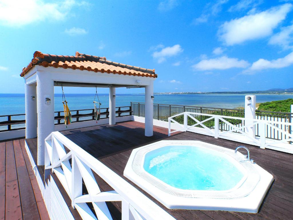 einen Whirlpool auf einer Terrasse mit einem Pavillon in der Unterkunft Haruhoo Resort ISHIGAKI in Ishigaki-jima