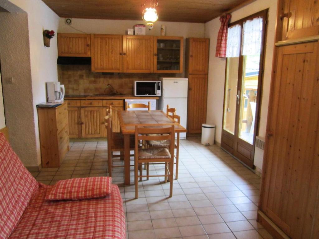 eine Küche mit einem Holztisch mit Stühlen und einem Tisch in der Unterkunft Appartement 5 pers. à l'entrée du village 70845 in Saint-Sorlin-dʼArves