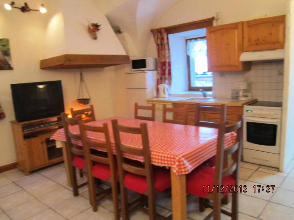 a kitchen with a table and chairs and a television at Appartement 8 pers. avec vue montagne 70848 in Saint-Sorlin-dʼArves