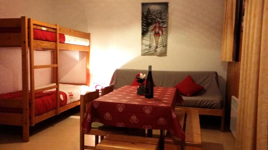 a room with a bed and a table and bunk beds at Studio 4 pers pied des pistes 80267 in Lanslevillard