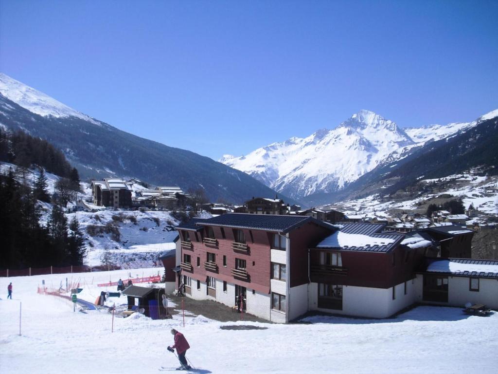 a person on skis in the snow in front of a building at Studio 5 personnes avec vue montagne 82171 in Lanslevillard