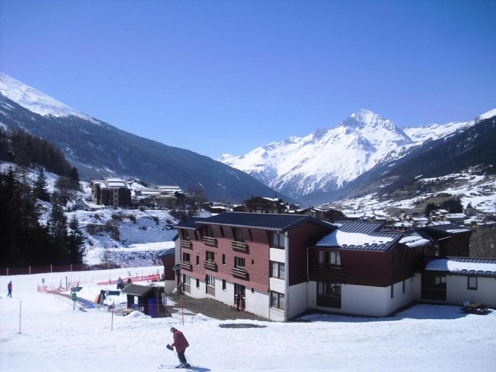 a person on skis in the snow in front of a building at Studio 5 personnes avec vue montagne à Val Cenis - Studio 5 personnes MAE-7798 in Lanslevillard