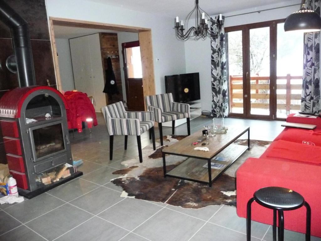 a living room with a red couch and a fireplace at Chalet belle vue montagne proche Valmorel 86009 in Valmorel