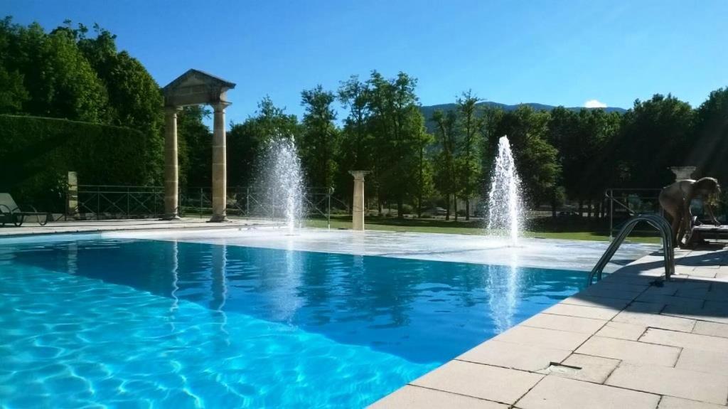 a pool with water fountains in a park at Appartement 4 pers. parc arboré de 4 ha 69018 in Montbrun-les-Bains