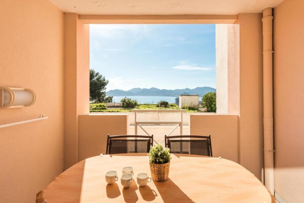 - une table dans une chambre avec une grande fenêtre dans l'établissement Résidence Cannes Villa Francia - maeva Home - Appartement 2 pièces 6 personnes - Sélection MAE-6118, à Cannes