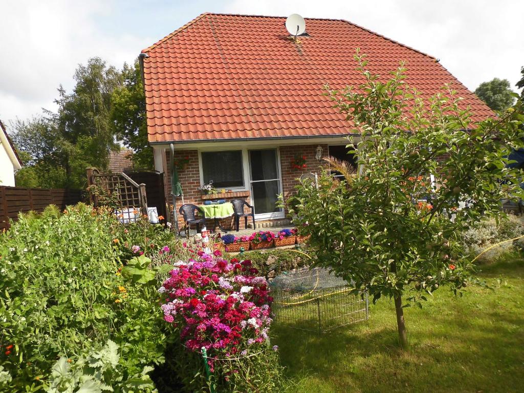 a house with a bunch of flowers in the yard at Zimmer in Hafennähe in Dierhagen