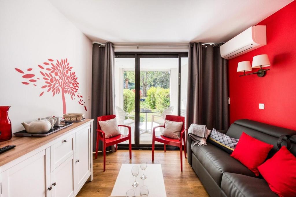 - un salon avec un canapé noir et des murs rouges dans l'établissement Résidence Cannes Villa Francia - maeva Home - Studio 4 Personnes - Sélection MAE-7833, à Cannes