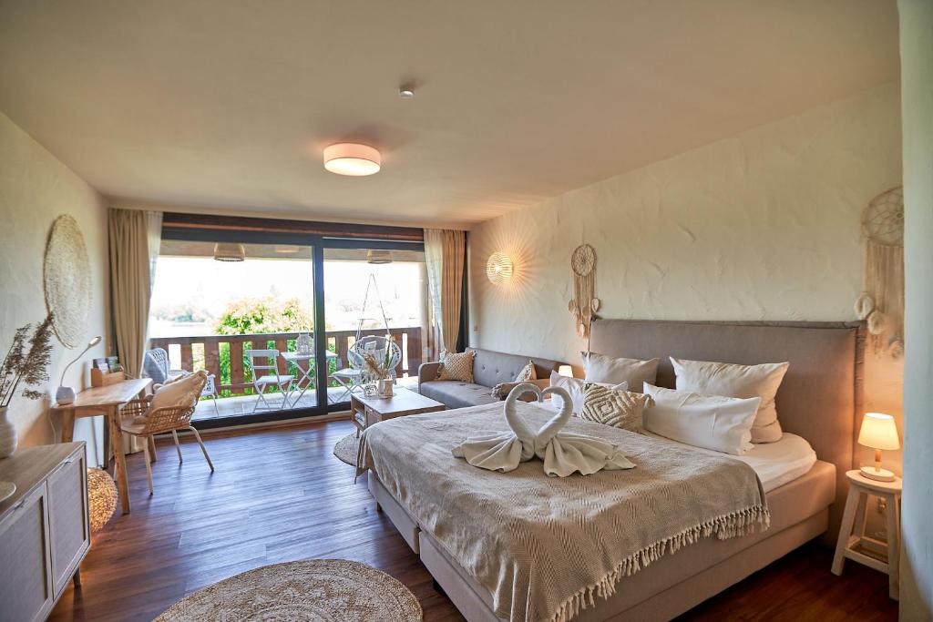 a bedroom with a large bed and a living room at Strandhaus Hotel in Parey