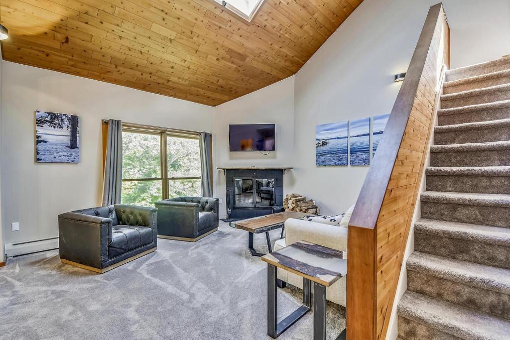a living room with stairs and a fireplace at Trail Creek 70 in Killington