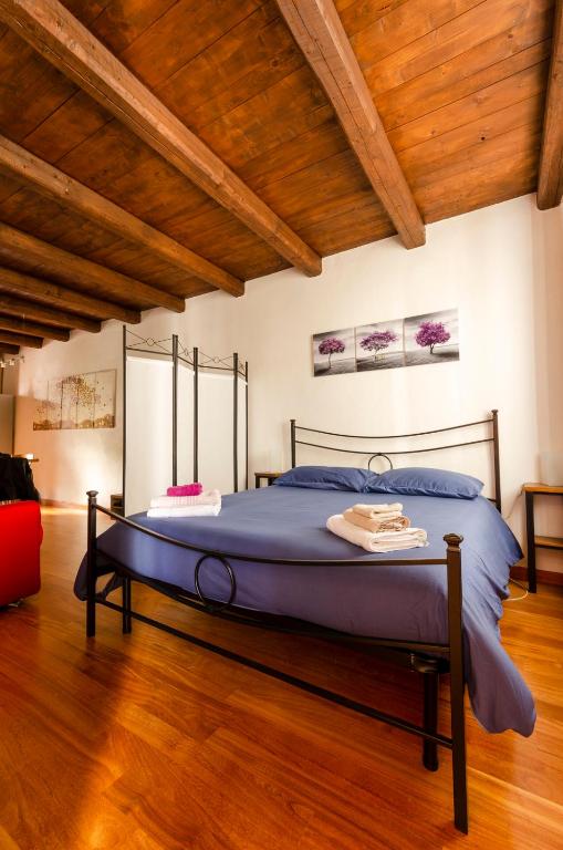 Cama grande en habitación con techo de madera en La Morra Flats, en La Morra