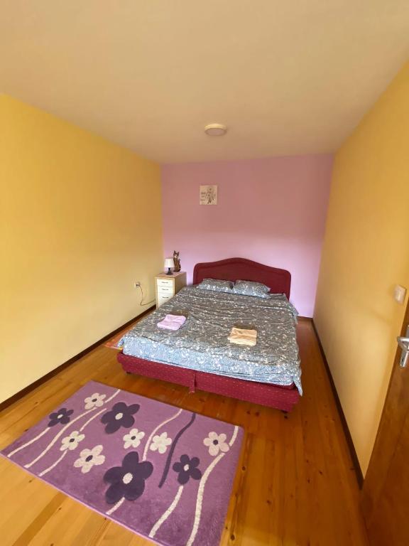 a bedroom with a bed and a purple rug at Apartman Mijovic - Nova Varos in Nova Varoš