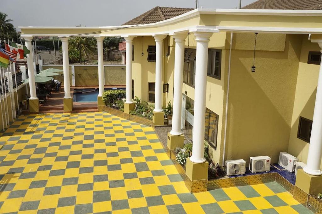 a courtyard of a building with a checkered floor at Sonia Hotel in Accra