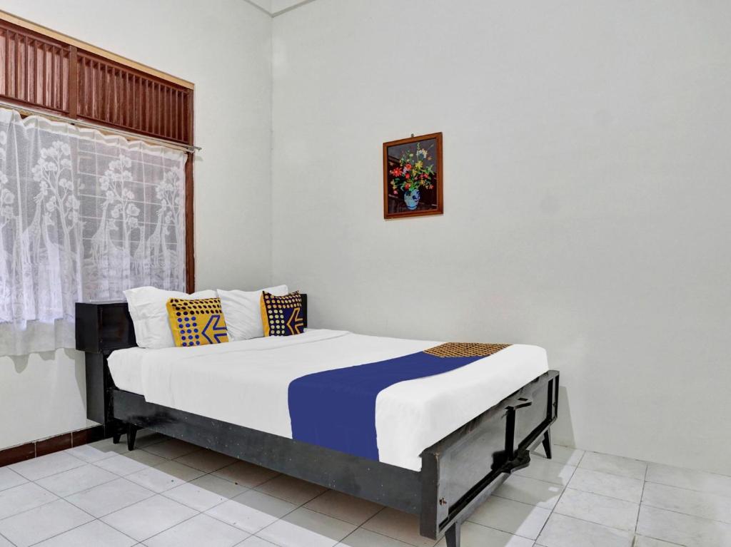 1 dormitorio con 1 cama en una habitación en OYO Life 90539 Taman Borobudur Guest House Syariah, en Blimbing