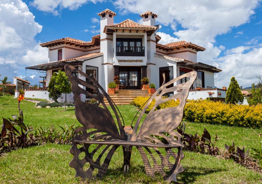 a butterfly chair in front of a house at Hotel & Spa - Caney campestre Villa de Leiva by MH in Villa de Leyva