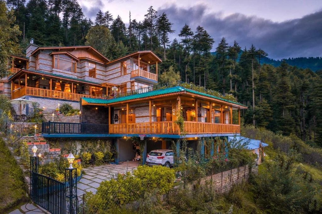 a large wooden house with a car parked in front of it at StayVista at The Wisteria House - Luxurious home with Lavish Interiors in Manāli