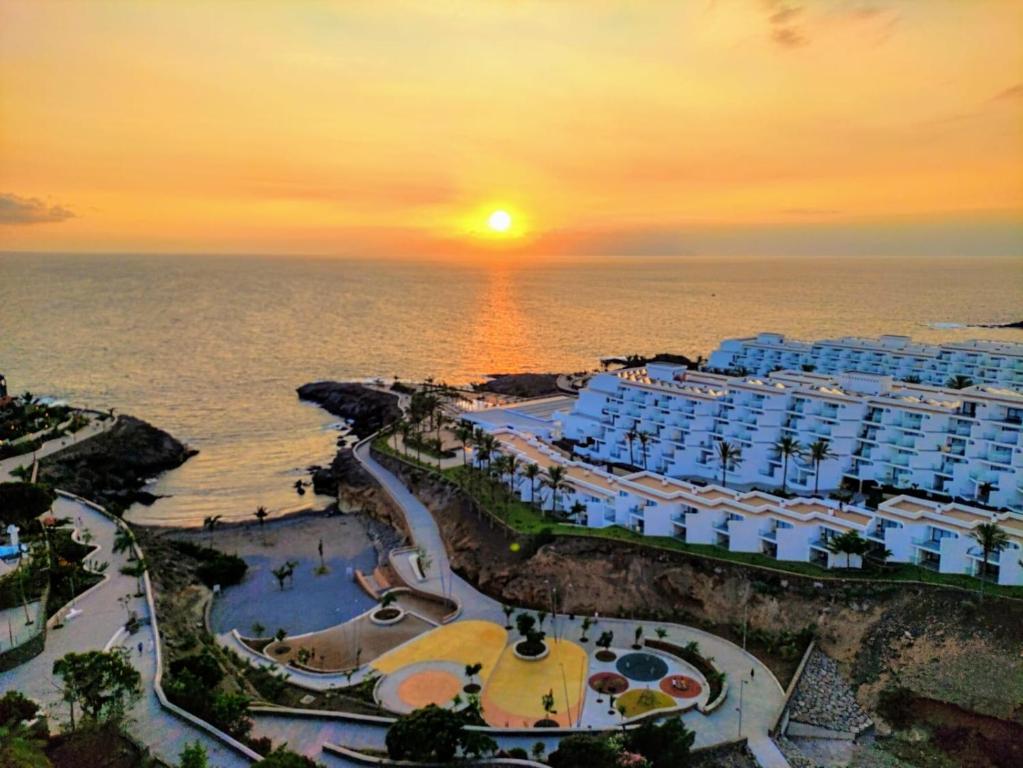 uma vista aérea de um resort perto do oceano ao pôr-do-sol em Ocean View Deluxe Studio em Playa Paraiso