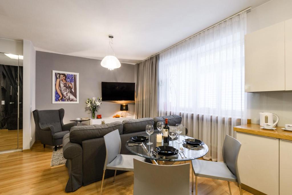 ワルシャワにあるNr 1 EUROPA22 CENTRUM Apartment Old Town Warsaw STARE MIASTO Historyczna kamienica umiejscowiona w zabytkowej części Warszawy PARKING 24h Śniadanie opcjonalnie Breakfast optional Check in from 13 pmのキッチン、リビングルーム(テーブル、ソファ付)